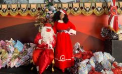 Simone Sampaio distribui presentes ao lado de Papai Noel de máscara na Dragões da Real